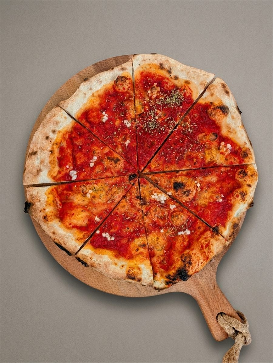 Pizza Marinara met tomatensaus, knoflook en oregano, in punten op een houten plank